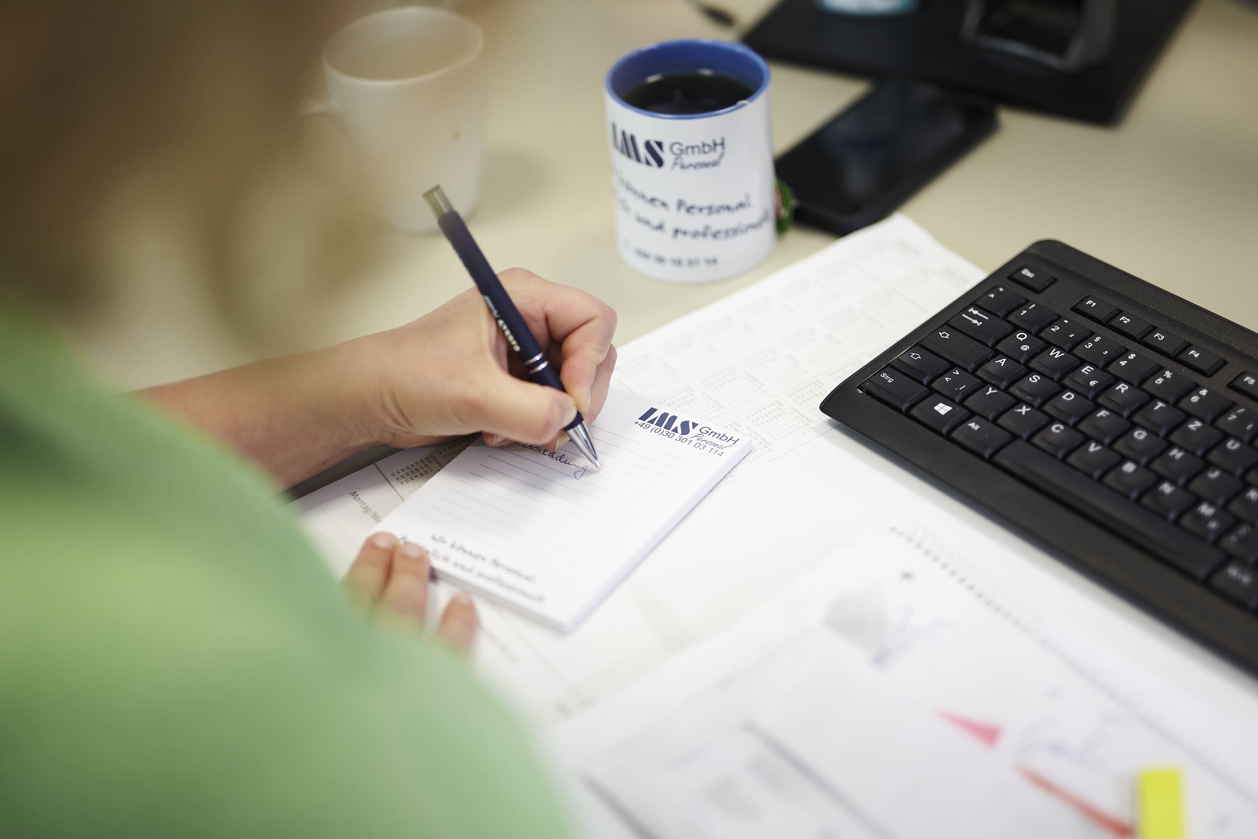 Mitarbeiterin der IMS Personal GmbH Berlin schreibt Notizen – sorgfältige Planung und Organisation in der externen Personalbeschaffung