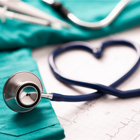 Stethoskop auf medizinischer Kleidung, dessen Schlauch ein Herz formt – Symbol für Pflege Jobs und Gesundheitsberufe. Brutto Netto Rechner für Pflege Jobs.